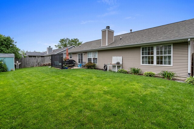 611 Northgate Dr, Saint Joseph, IL 61873 - back of property with a chimney, a patio, and roof with shingles