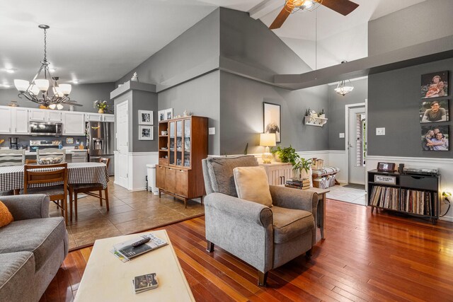 611 Northgate Dr, Saint Joseph, IL 61873 - living area featuring a chandelier, ceiling fan, wood-type flooring, wainscoting, and a high ceiling