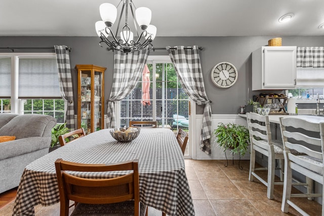 611 Northgate Dr, Saint Joseph, IL 61873 - dining room featuring a chandelier, light tile patterned flooring, and wainscoting