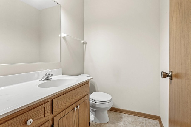 bathroom featuring vanity, baseboards, tile patterned floors, and toilet