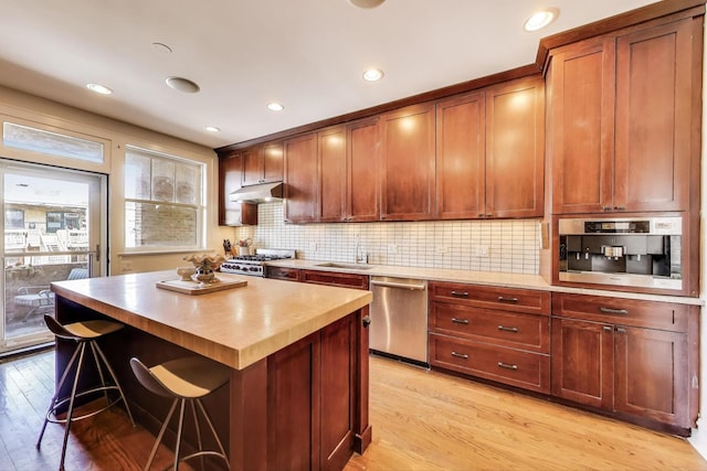 918 Michigan Ave Unit 3, Evanston, IL 60202 - kitchen featuring stainless steel dishwasher, under cabinet range hood, light wood-style floors, stove, and recessed lighting