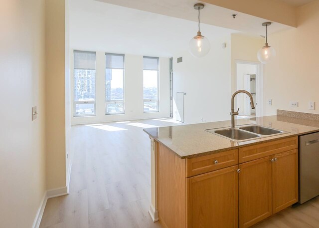 kitchen with a peninsula, light wood-style floors, a sink, dishwasher, and decorative light fixtures