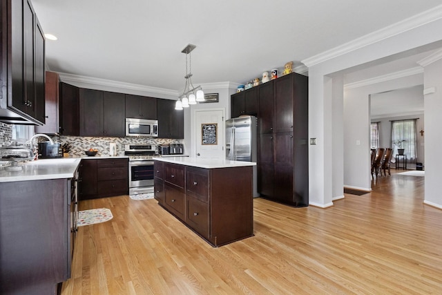 1000 Salvia Ln, Joliet, IL 60431 - kitchen featuring light wood finished floors, stainless steel appliances, crown molding, backsplash, and light countertops