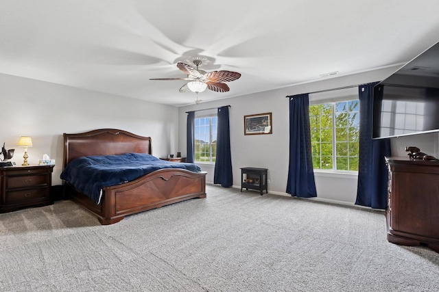 1000 Salvia Ln, Joliet, IL 60431 - carpeted bedroom with a wood stove, visible vents, baseboards, and a ceiling fan