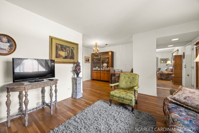 living room with baseboards, wood finished floors, and a chandelier