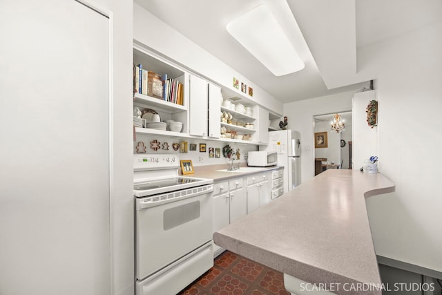 kitchen with light countertops, white cabinets, open shelves, and white appliances