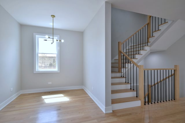 2123 N Austin Ave, Chicago, IL 60639 - stairs featuring baseboards, visible vents, wood finished floors, and a chandelier