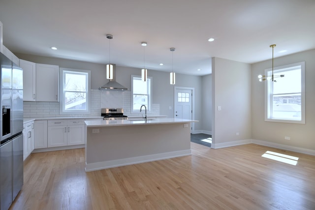2123 N Austin Ave, Chicago, IL 60639 - kitchen with a sink, appliances with stainless steel finishes, light wood finished floors, and wall chimney exhaust hood