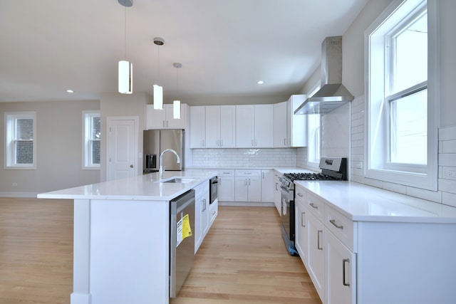 2123 N Austin Ave, Chicago, IL 60639 - kitchen featuring wall chimney range hood, a sink, light wood-style flooring, appliances with stainless steel finishes, and backsplash