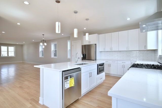 2123 N Austin Ave, Chicago, IL 60639 - kitchen with appliances with stainless steel finishes, tasteful backsplash, a sink, light wood-style floors, and wall chimney exhaust hood