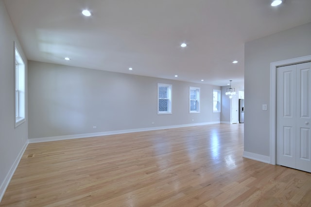 2123 N Austin Ave, Chicago, IL 60639 - empty room with baseboards, recessed lighting, light wood-style flooring, and a notable chandelier