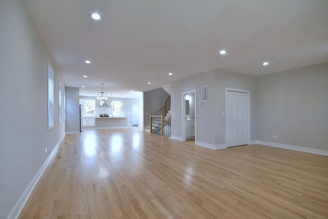 2123 N Austin Ave, Chicago, IL 60639 - unfurnished living room featuring recessed lighting, visible vents, light wood-style flooring, and stairway