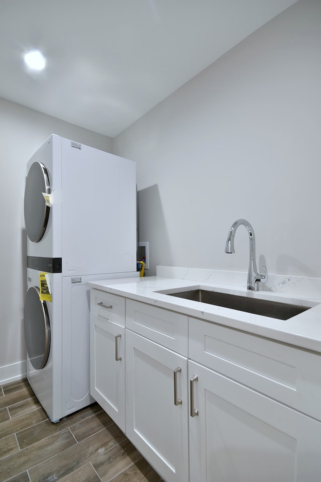 2123 N Austin Ave, Chicago, IL 60639 - laundry area featuring stacked washer and clothes dryer, baseboards, dark wood finished floors, a sink, and cabinet space