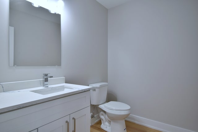 2123 N Austin Ave, Chicago, IL 60639 - bathroom with baseboards, vanity, toilet, and wood finished floors