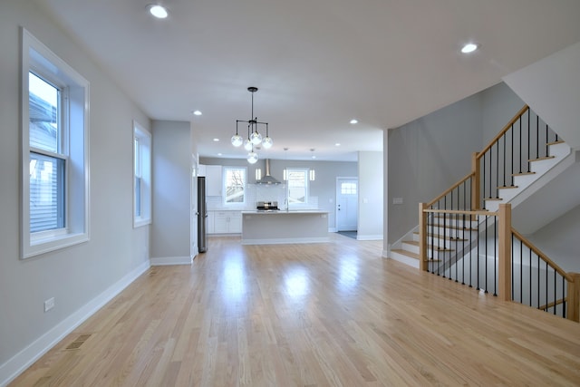 2123 N Austin Ave, Chicago, IL 60639 - unfurnished living room featuring an inviting chandelier, light wood finished floors, recessed lighting, baseboards, and stairway
