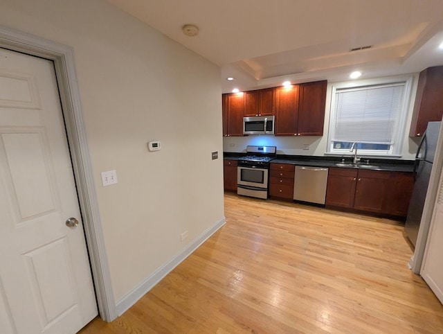 6912 N Lakewood Ave Unit 1W, Chicago, IL 60626 - kitchen featuring dark countertops, appliances with stainless steel finishes, a sink, and light wood-type flooring