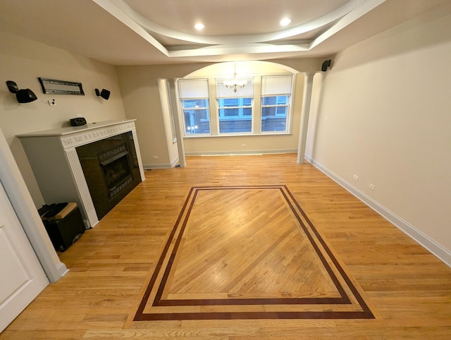 6912 N Lakewood Ave Unit 1W, Chicago, IL 60626 - unfurnished living room featuring an inviting chandelier, a raised ceiling, a fireplace, and light wood-type flooring