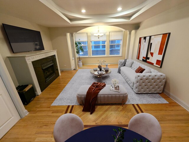 6912 N Lakewood Ave Unit 1W, Chicago, IL 60626 - living room with a fireplace, a raised ceiling, baseboards, light wood finished floors, and an inviting chandelier