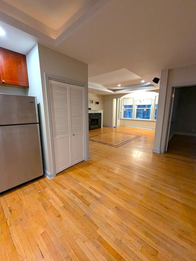 6912 N Lakewood Ave Unit 1W, Chicago, IL 60626 - unfurnished living room featuring light wood-style floors, recessed lighting, a tray ceiling, and a fireplace