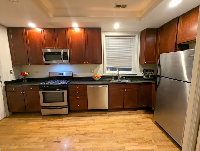 6912 N Lakewood Ave Unit 1W, Chicago, IL 60626 - kitchen featuring a tray ceiling, appliances with stainless steel finishes, dark countertops, and a sink