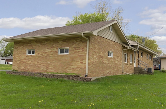 view of property exterior with a lawn, central AC, and brick siding