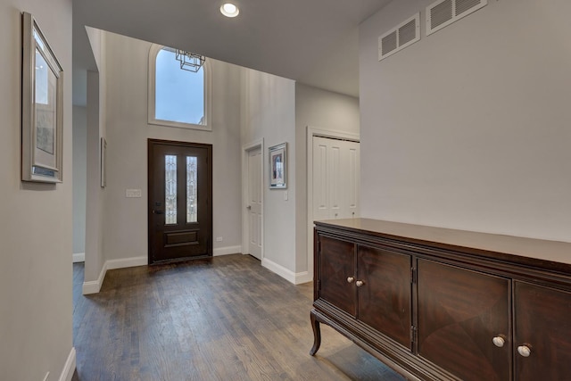 foyer entrance with dark wood-style flooring, baseboards, visible vents, and recessed lighting