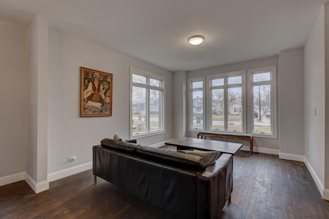 living room featuring baseboards and dark wood-style flooring