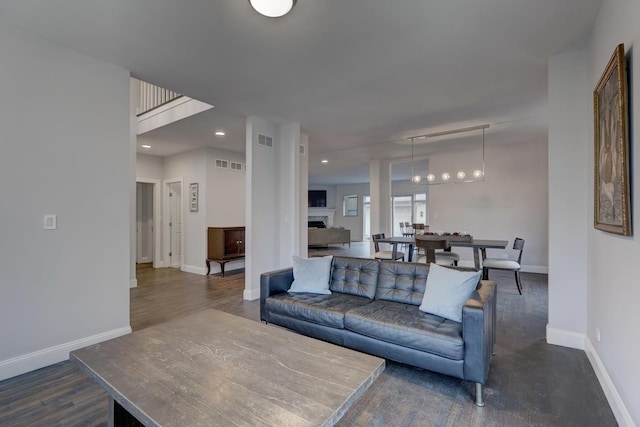 living room featuring recessed lighting, baseboards, dark wood-style flooring, and visible vents