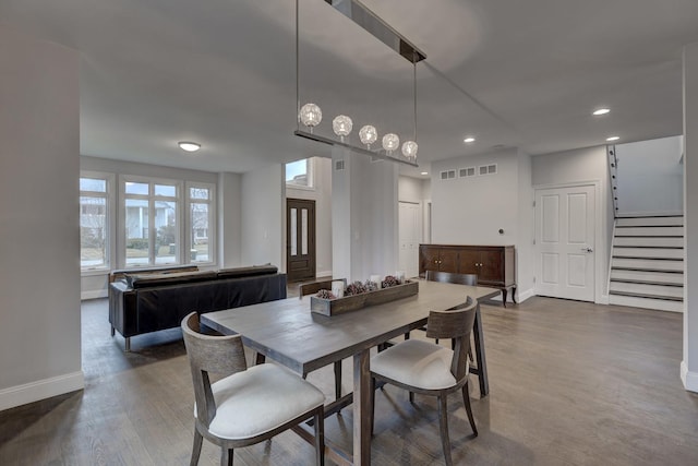 dining area with dark wood-style flooring, visible vents, stairs, baseboards, and recessed lighting