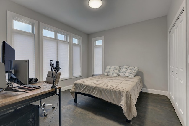 bedroom with baseboards, a closet, and dark wood-style floors