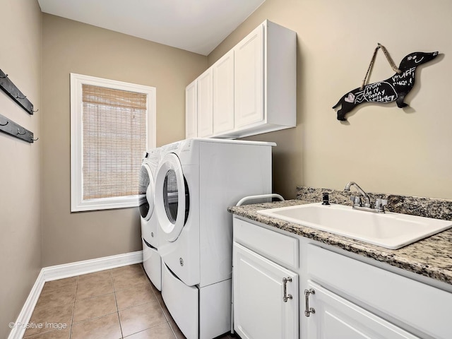 clothes washing area featuring washer and dryer, cabinet space, a sink, baseboards, and light tile patterned floors