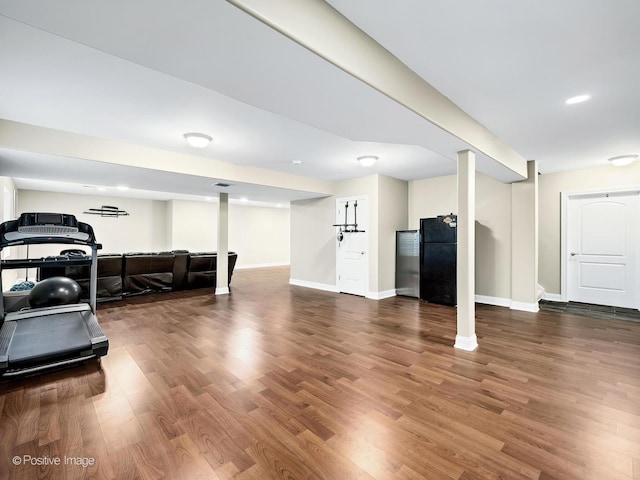 workout area with baseboards and wood finished floors