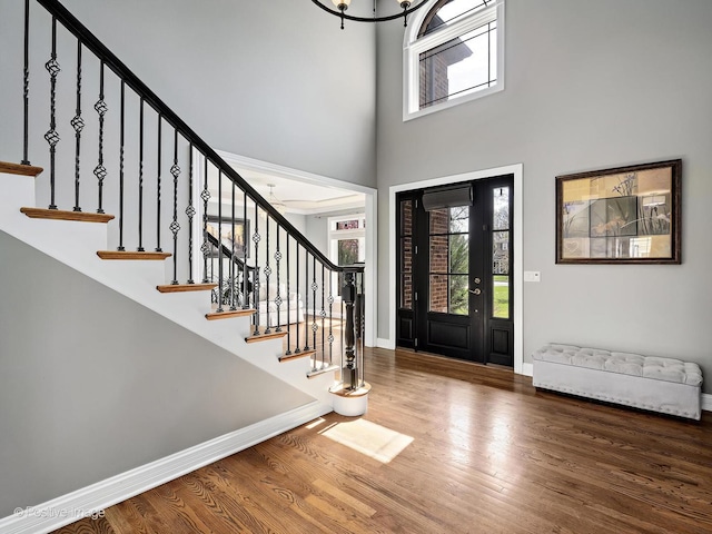 entryway featuring stairway, baseboards, a high ceiling, and wood finished floors