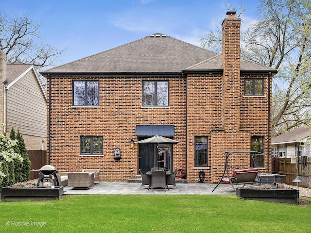 back of property featuring a chimney, roof with shingles, brick siding, fence, and a patio