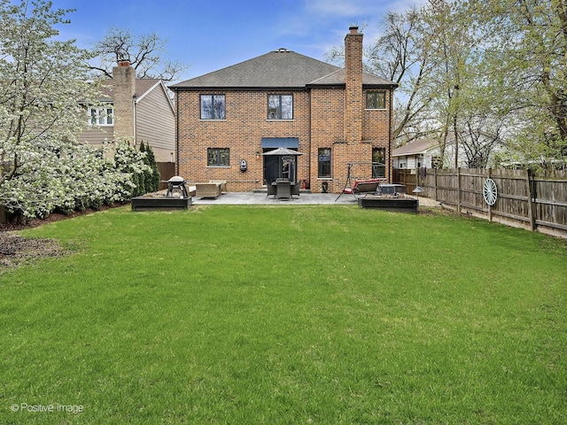 rear view of property with a patio, fence, a yard, and a chimney