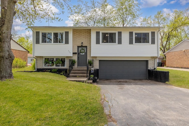 bi-level home with a garage, driveway, and a front yard