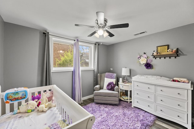 bedroom featuring a ceiling fan, wood finished floors, and visible vents