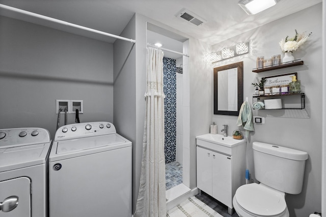 full bath with visible vents, vanity, toilet, separate washer and dryer, and a stall shower