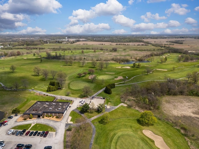 drone / aerial view with view of golf course and a water view