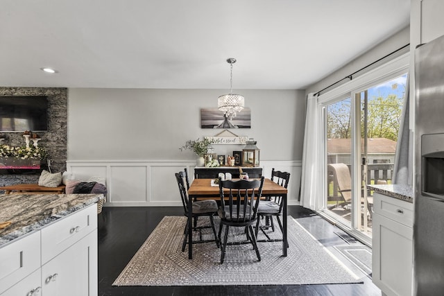 dining space with dark wood-type flooring, recessed lighting, a decorative wall, and a wainscoted wall