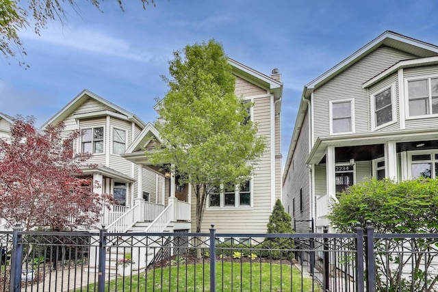 view of front of property with a fenced front yard and a porch