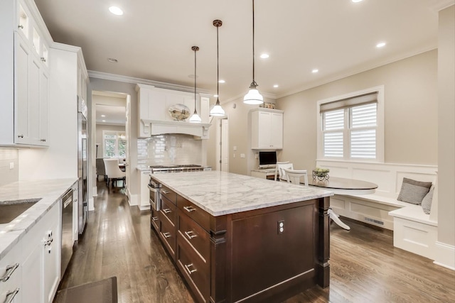 kitchen featuring white cabinets, crown molding, dark brown cabinetry, decorative backsplash, and dark wood-type flooring