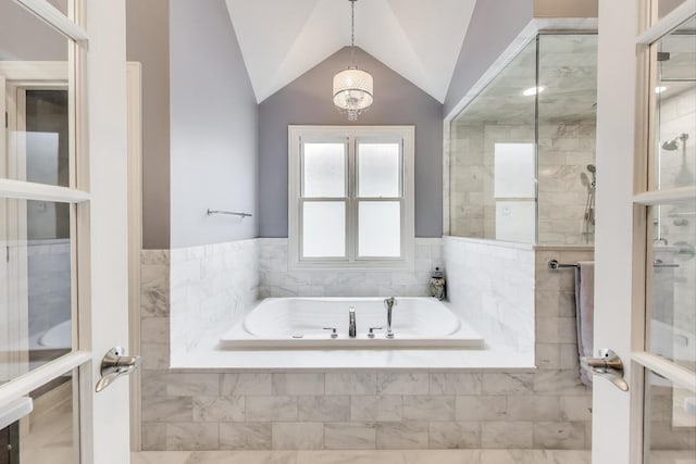 full bathroom featuring a garden tub, vaulted ceiling, and a tile shower
