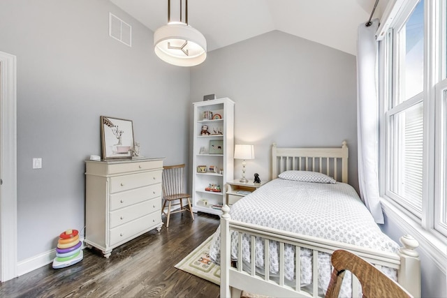 bedroom with multiple windows, vaulted ceiling, dark wood-style floors, and baseboards
