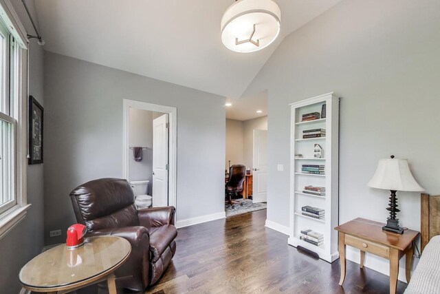 living area with wood finished floors, an office area, baseboards, and high vaulted ceiling