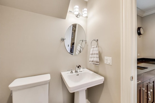 bathroom featuring ornamental molding and toilet
