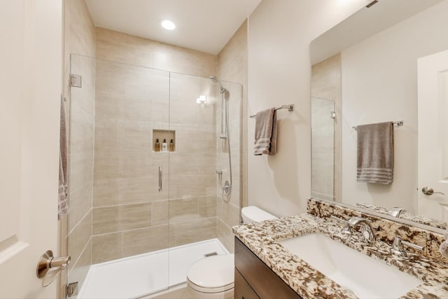 bathroom featuring toilet, a shower stall, vanity, and recessed lighting