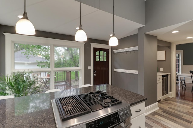 1314 E Washington St, Bloomington, IL 61701 - kitchen featuring hanging light fixtures, white cabinetry, stainless steel range with gas cooktop, wine cooler, and light wood-style flooring