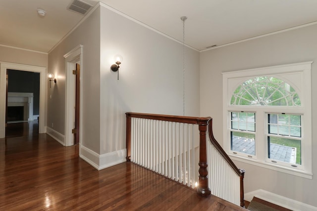 1314 E Washington St, Bloomington, IL 61701 - hall featuring visible vents, crown molding, wood finished floors, baseboards, and an upstairs landing