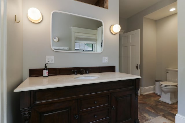 1314 E Washington St, Bloomington, IL 61701 - bathroom with vanity, stone finish flooring, baseboards, and toilet